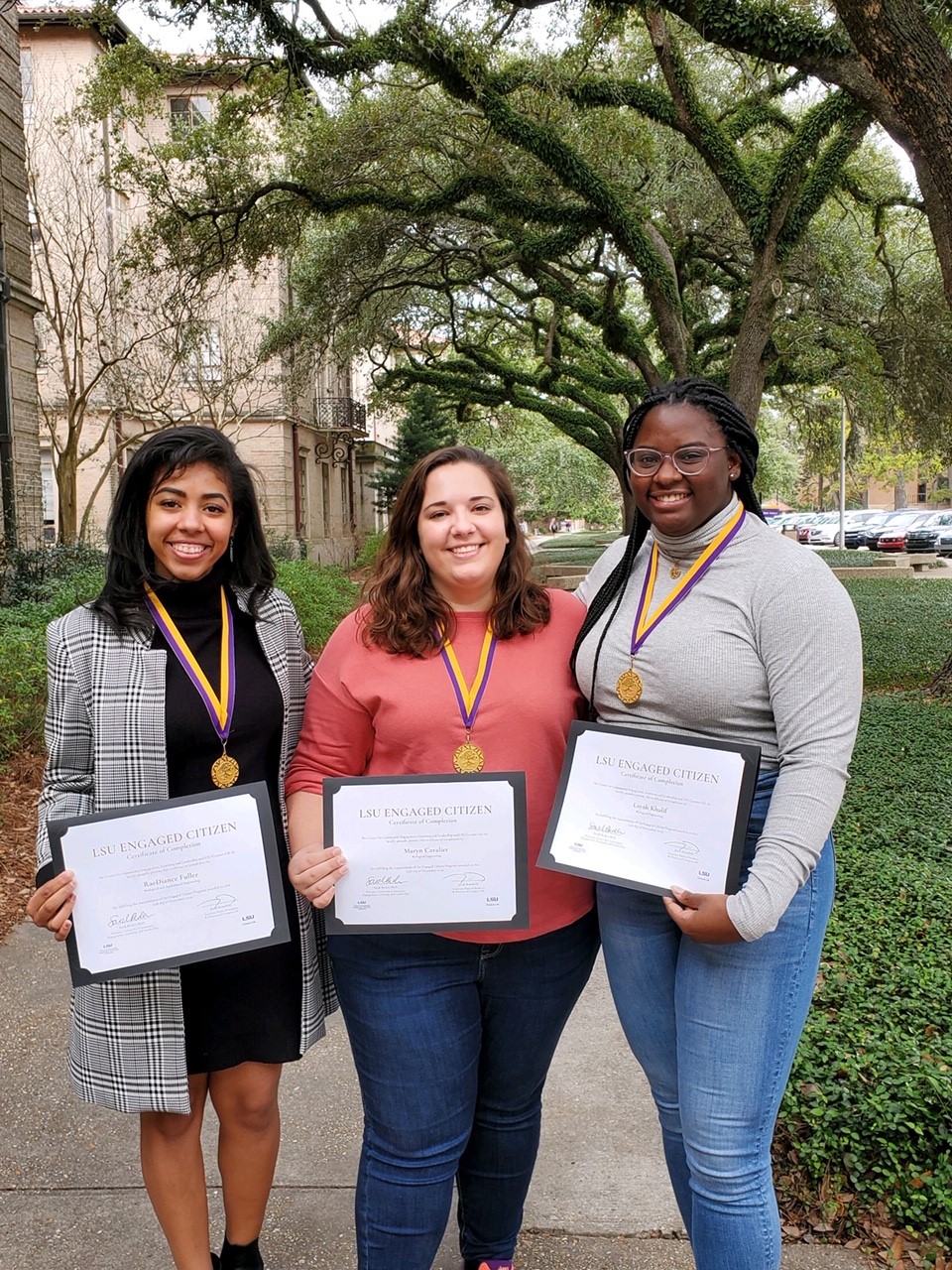 group of students holding certificates outside