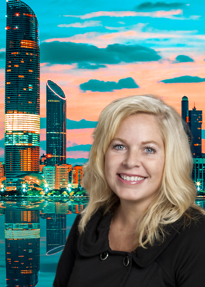 Jenn Curry in front of a scene from Dubai