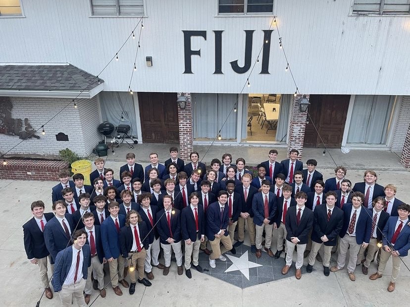 fiji members in suits under fiji sign