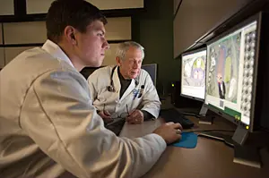 faculty in a medical lab looking at screens