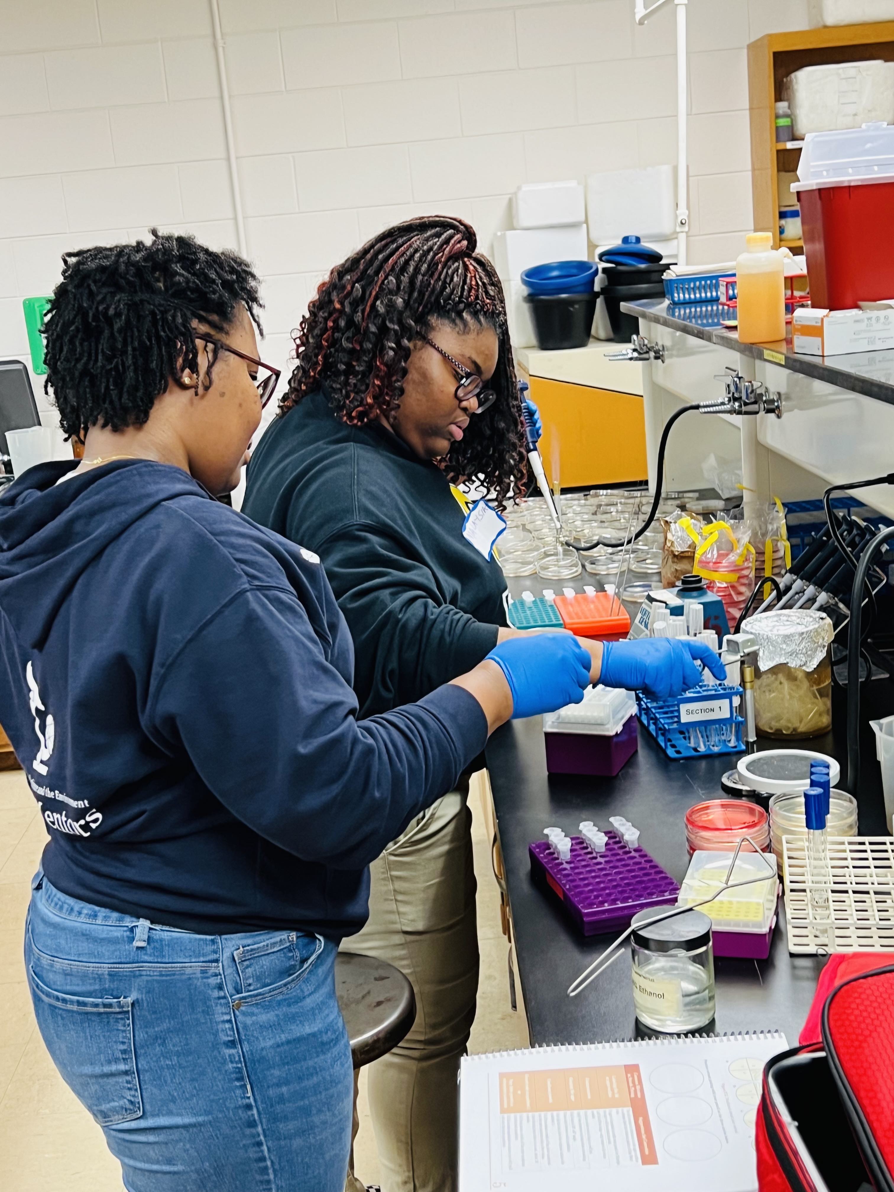 Elaine mentoring high school students in the lab